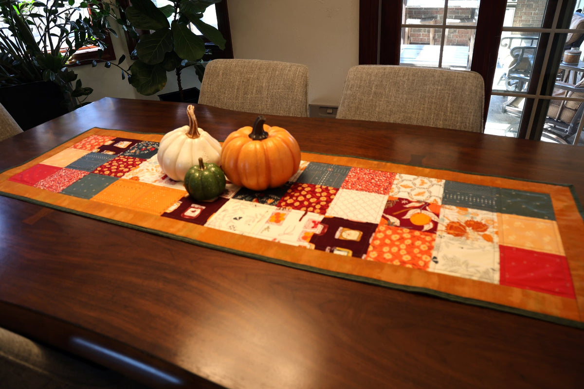 Season & Spice patchwork table runner with pumpkins on a dining table